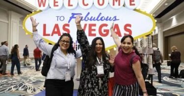 IMEX America attendees pose in front of a Welcome to Las Vegas sign. image courtesy of IMEX | eTurboNews | eTN
